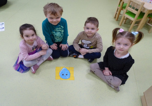 Dzieci dumnie prezentują swoje ułożone puzzle.